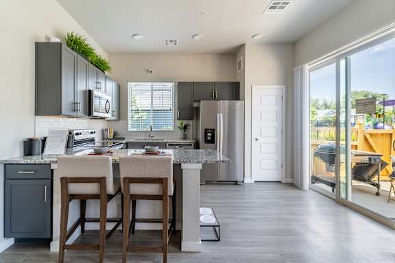 A kitchen with a bar stool and a counter.