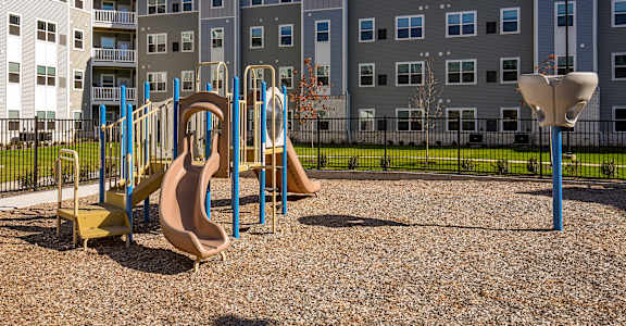 A playground with a slide and a yellow and brown slide.