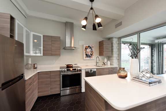 A modern kitchen with a stainless steel refrigerator and a white countertop.