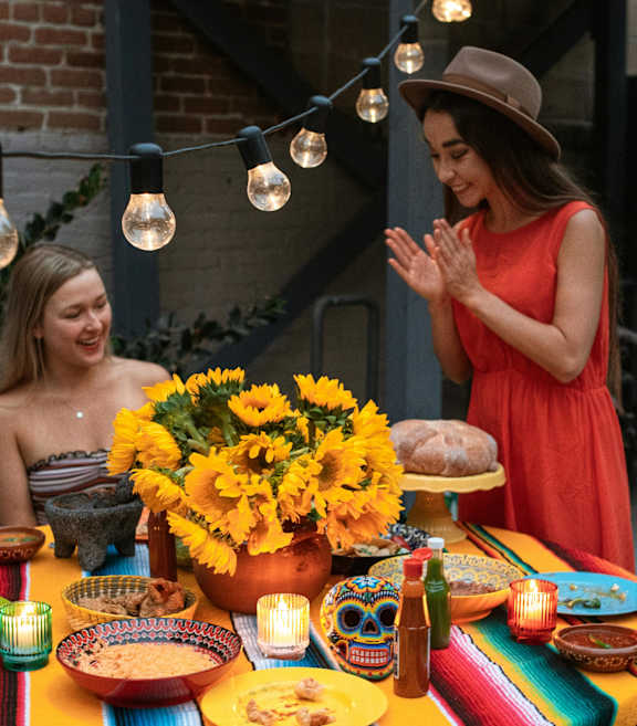 A group of people are sitting around a colorful table enjoying a meal together.