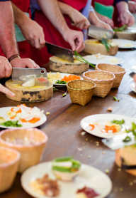 a group of people preparing food at a table