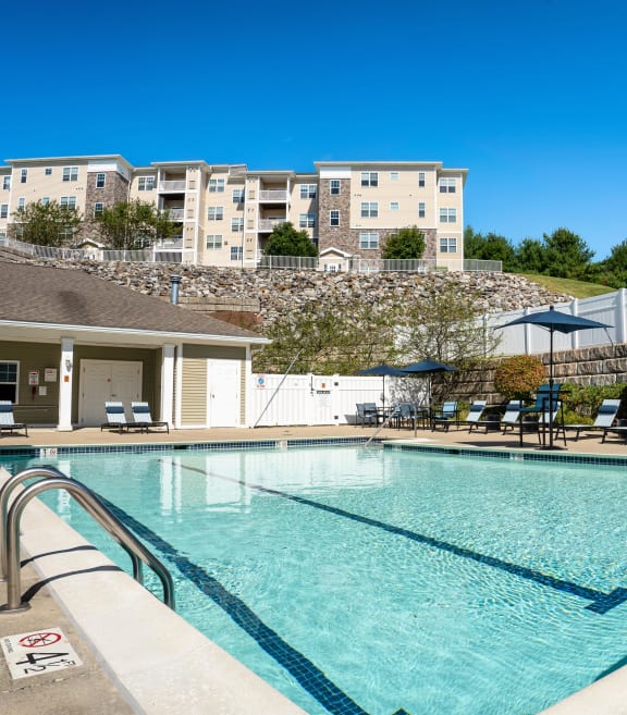 a swimming pool with a house in the background