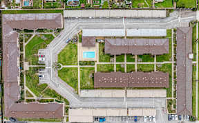 A bird's eye view of a residential area with a swimming pool and apartment buildings.