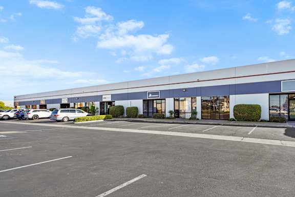 A large industrial building with a parking lot in front.