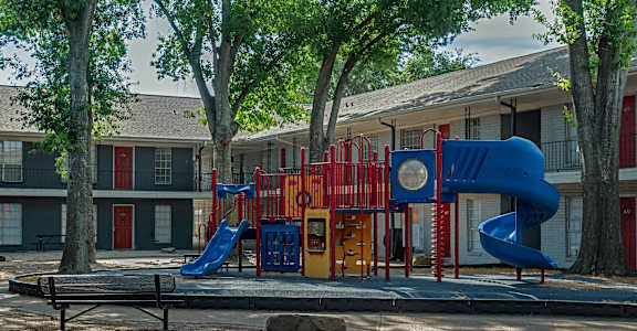A playground with a blue slide and a red and yellow play structure.