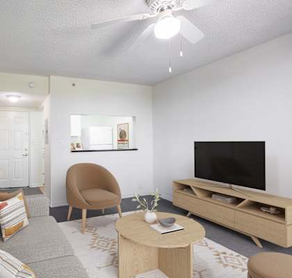 A living room with a grey sofa, a brown chair, a wooden coffee table, and a television.