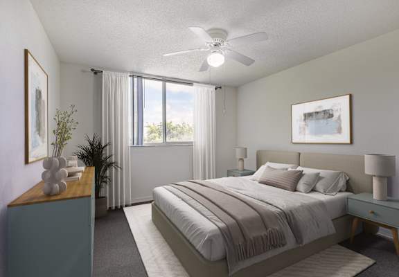A bedroom with a large bed and a ceiling fan.