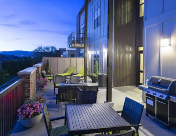 A patio with a table and chairs and a grill at Sugar House Apartments By Urbana, Salt Lake City, UT, 84105