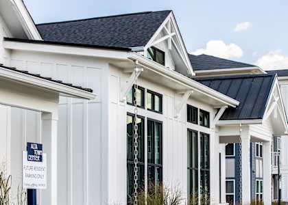 the exterior of a white home with black roof and windows
