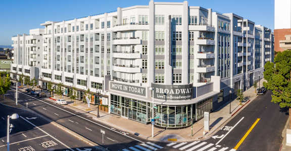 a large white building with a sign on it on a city street