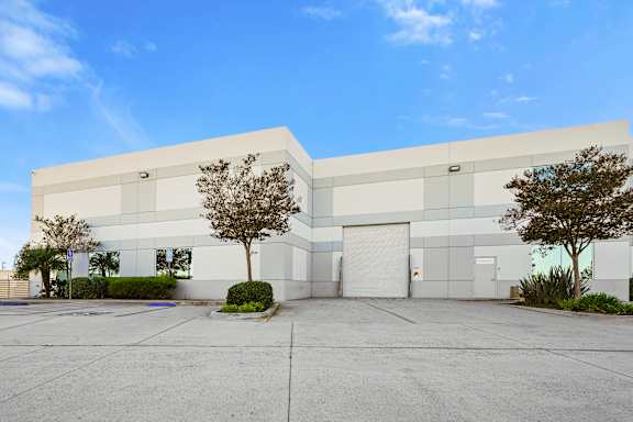 A large white building with a tree in front of it.