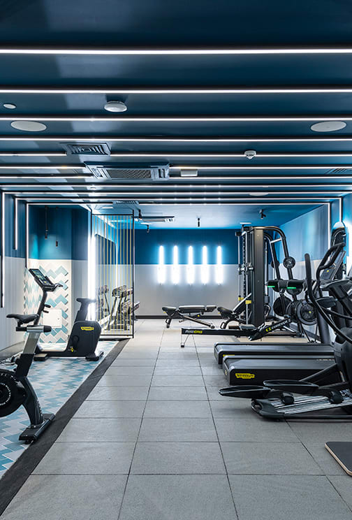 a gym with exercise equipment and blue walls