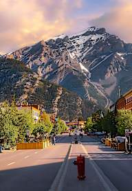 A street in a town with a mountain in the background.