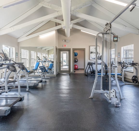 the gym with cardio equipment and weights at the belgard apartments