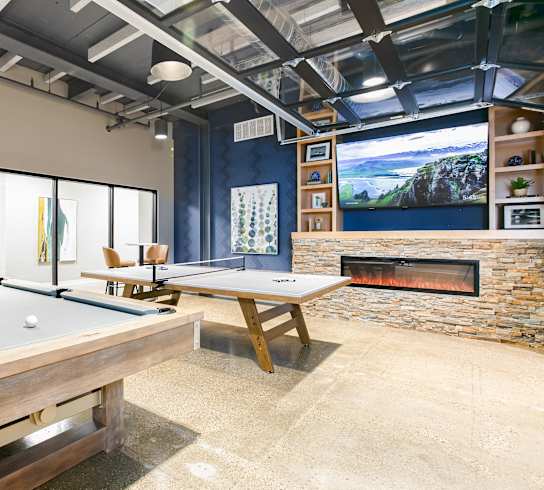 a game room with two pool tables and a fireplace