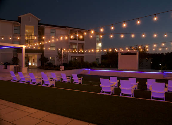 A string of lights is strung across a patio.
