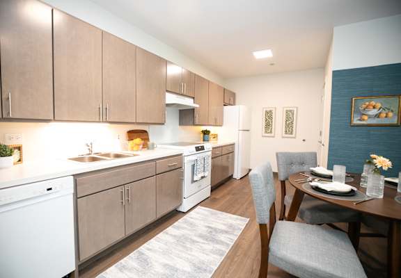 A modern kitchen with a dining table set for two.