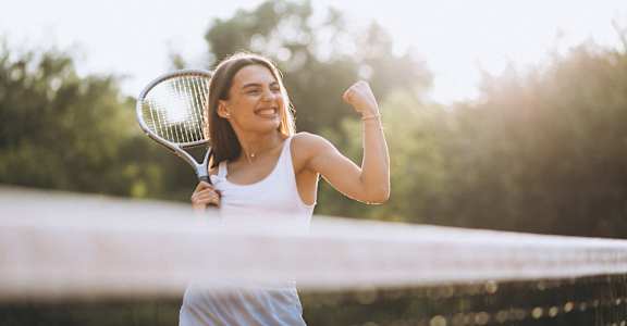 Woman Smiling while Playing Tennis