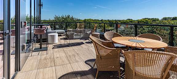 a patio with tables and chairs on a balcony