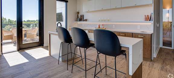 a kitchen with a white counter top and blue chairs