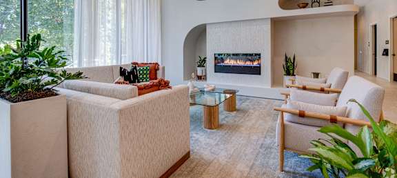 a living room with white furniture and a fireplace