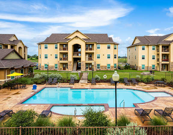 A large building with a pool in front of it.