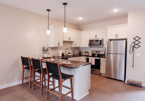 a kitchen with stainless steel appliances and a island with bar stools