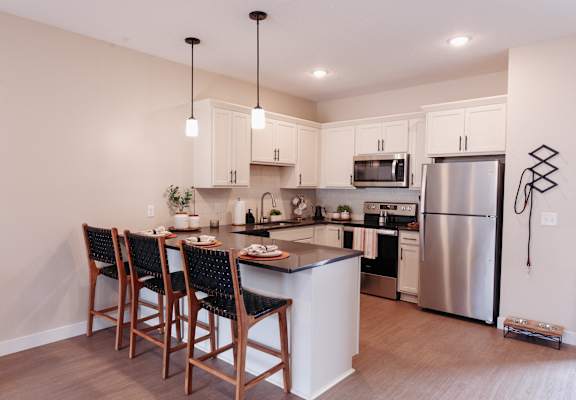 a kitchen with stainless steel appliances and a island with bar stools