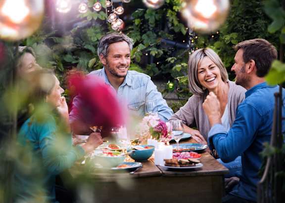 A group of people are sitting around a table enjoying a meal together.