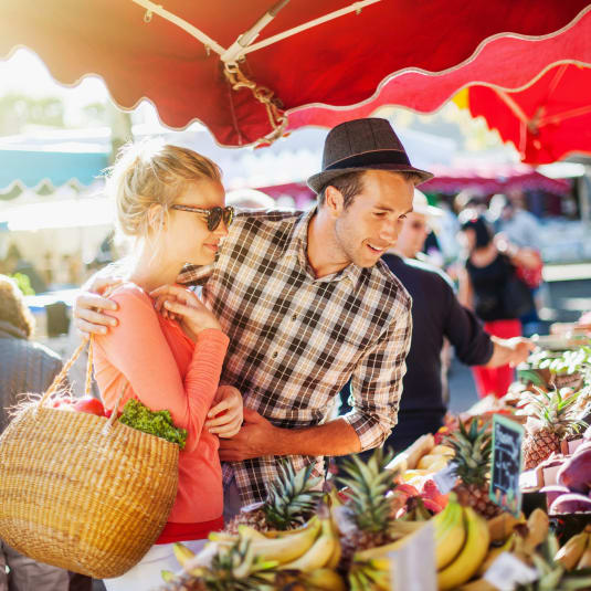 Man and a woman shopping at a fruit market