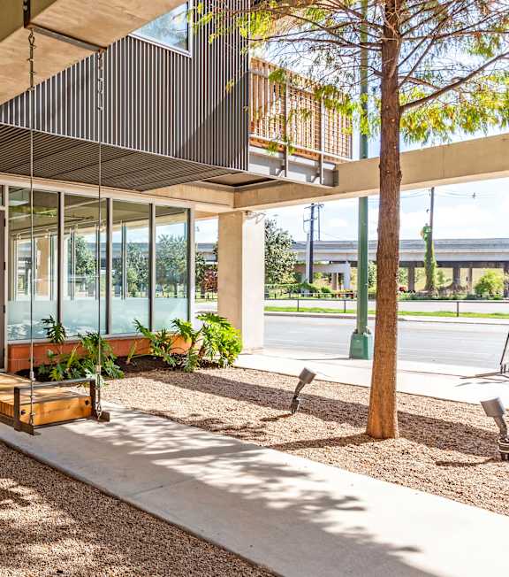 A modern building with a glass entrance and a tree in front.