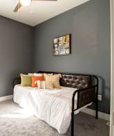 A bedroom with a bed, pillows, and a window.