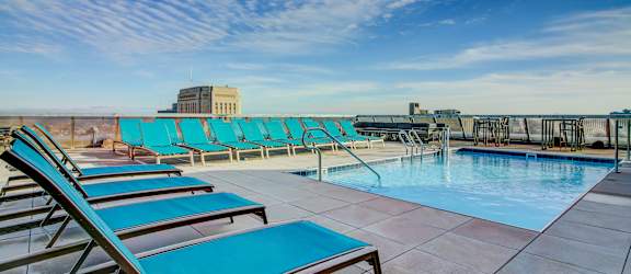 the sign for the grand atrium on the roof of a building with a pool  at The Grand, Kansas City, MO, 64106