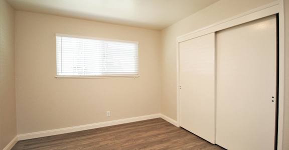 an empty bedroom with a closet and a window