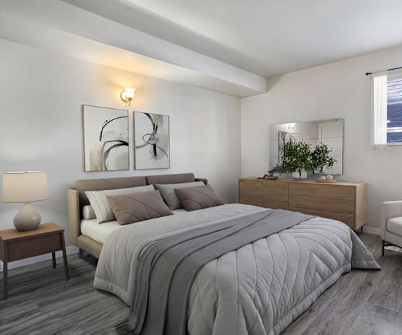 A bedroom with a large bed, a nightstand, and a chair.