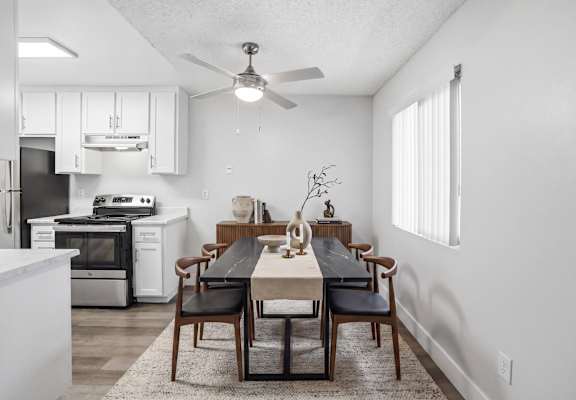 A modern kitchen with a dining table set for four.