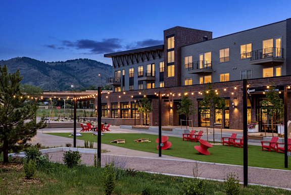 A modern building with a patio area and outdoor furniture.