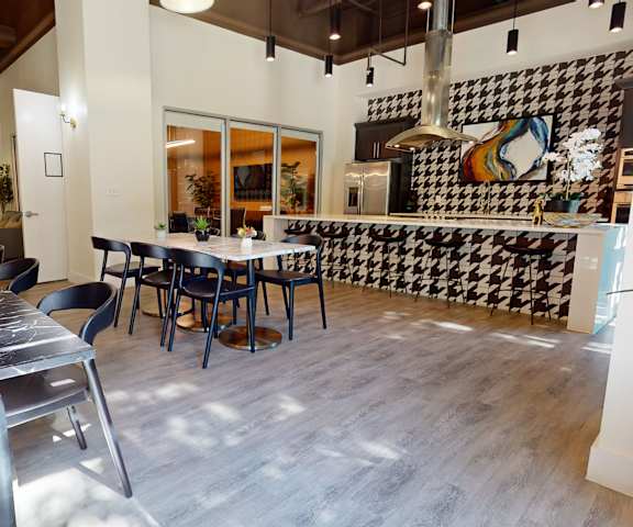 A resident lounge with tables, chairs, and a pool table at Lofts at Watters Creek Apartments. 