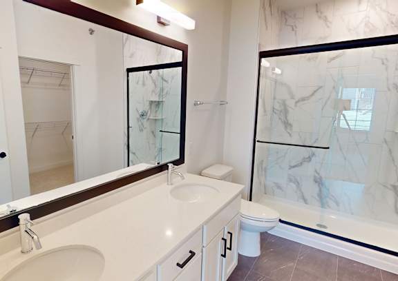 A white sink in a bathroom with a mirror above it.