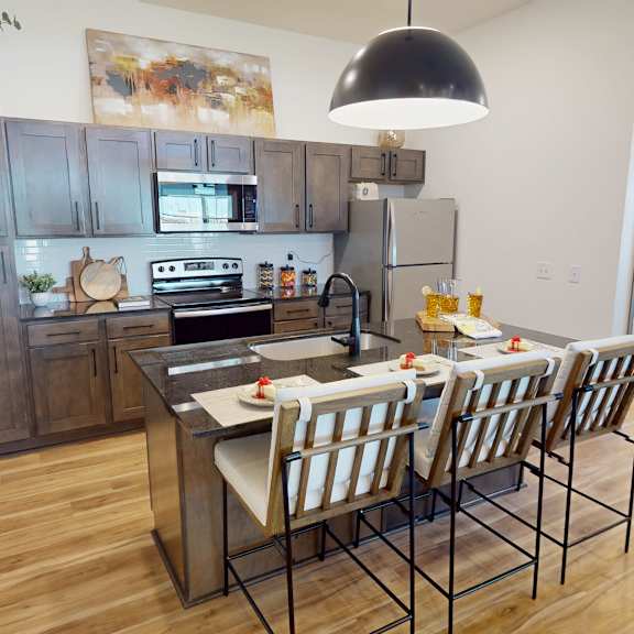 A kitchen with a table and chairs in front of a refrigerator.