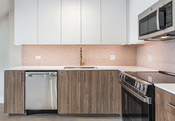 A kitchen with a stainless steel dishwasher and oven.