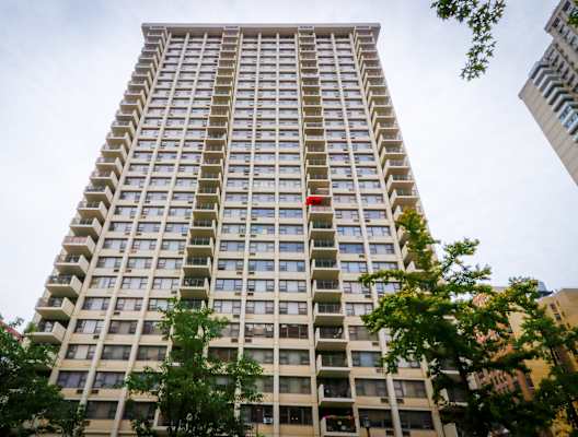 a tall apartment building with many windows and a red