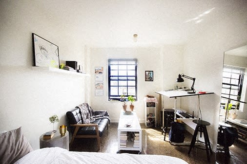 a small living room with a bed and a desk