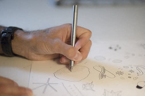 a hand holding a pen and writing on a sheet of paper