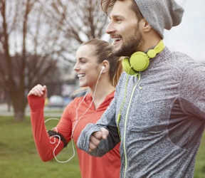 A man and a woman are jogging together in a park.