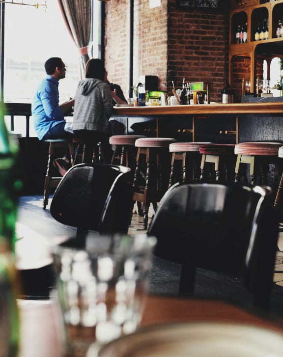 a couple sitting at a bar in a restaurant