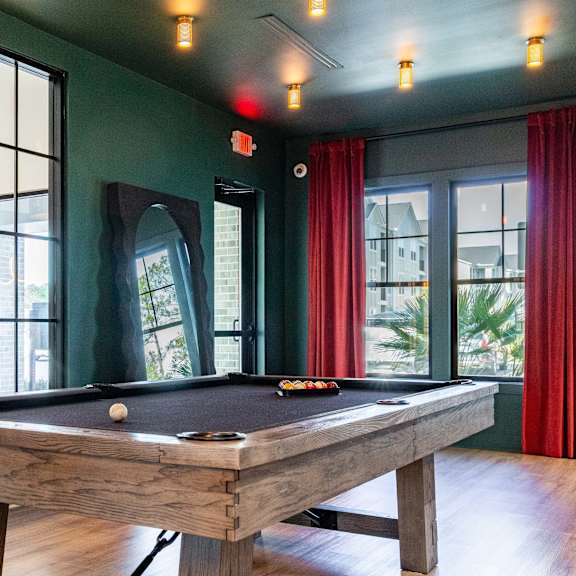 A pool table in a room with a view of the city.