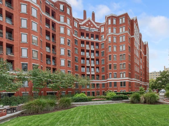a green lawn in front of two brick buildings at The Saratoga Apartments, Washington, DC 20008