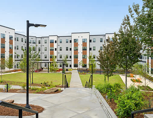 A modern apartment complex with a walkway leading to the entrance.