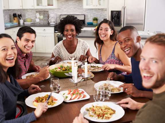 a group of people sitting around a table eating food